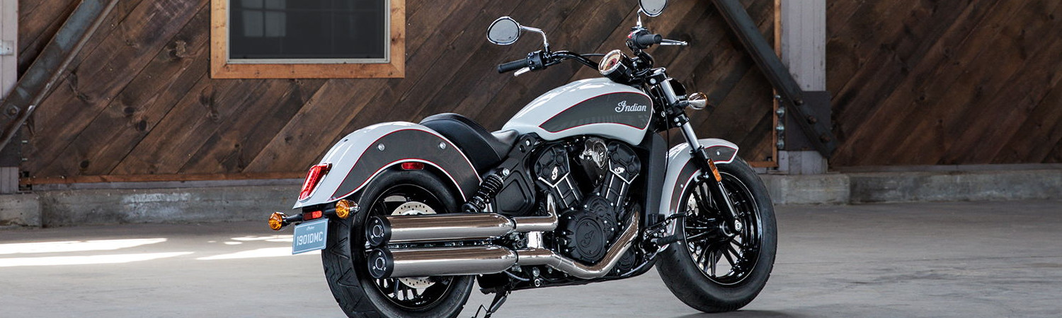 Silver 2020 Indian Motorcycle® Scout parked on the side of the road in front of a building